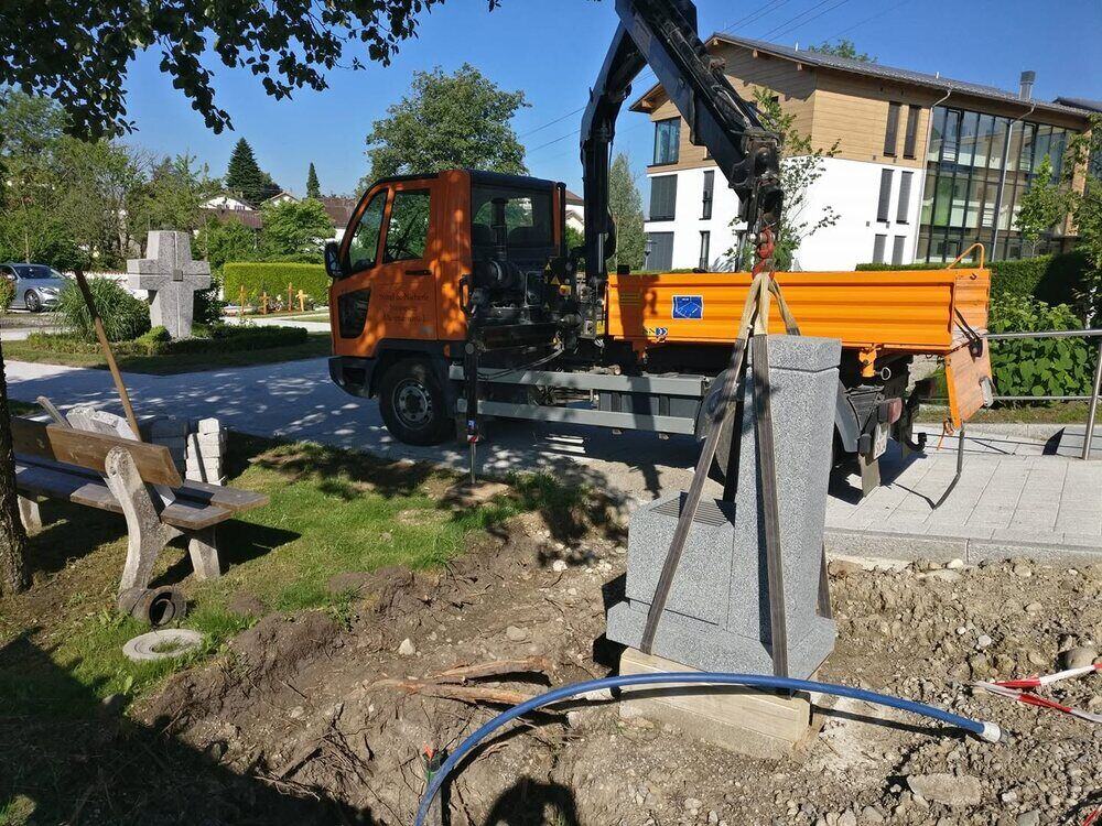 Grabsetzung mit dem eigenen Kran auf dem Friedhof.